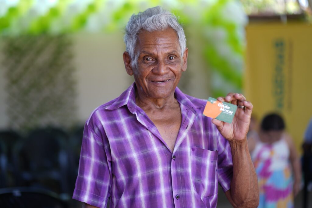 Famílias de Divinópolis são beneficiadas com Aluguel Social nesta segunda-feira - homem negro de aproximadamente 70 anos segurando cartão do Aluguel Social