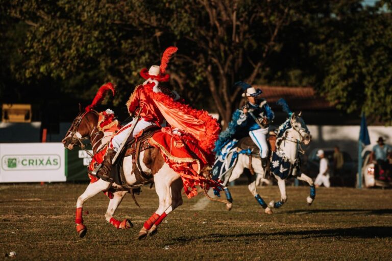Cavalhadas de Crixás preservam tradição centenária em Goiás - encenação da batalha entre mouros e cristãos - cavaleiros em cavalos brancos e vestindo trajes nas cores azul e vermelha