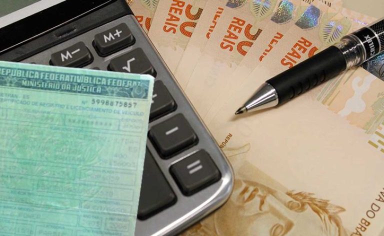 Débitos negociados de ICMS, IPVA e ITCD vencem nesta segunda - documento de carro, calculadora, caneta e notas de R$ 50
