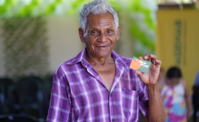 Famílias de Divinópolis são beneficiadas com Aluguel Social nesta segunda-feira - homem negro de aproximadamente 70 anos segurando cartão do Aluguel Social