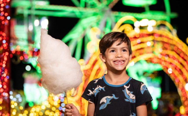 Garotinho em frente à roda-gigante do Natal do Bem